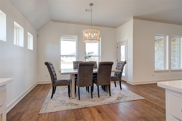 dining area featuring baseboards, wood finished floors, visible vents, and a healthy amount of sunlight