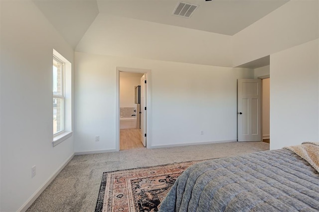 bedroom with light colored carpet, visible vents, connected bathroom, vaulted ceiling, and baseboards