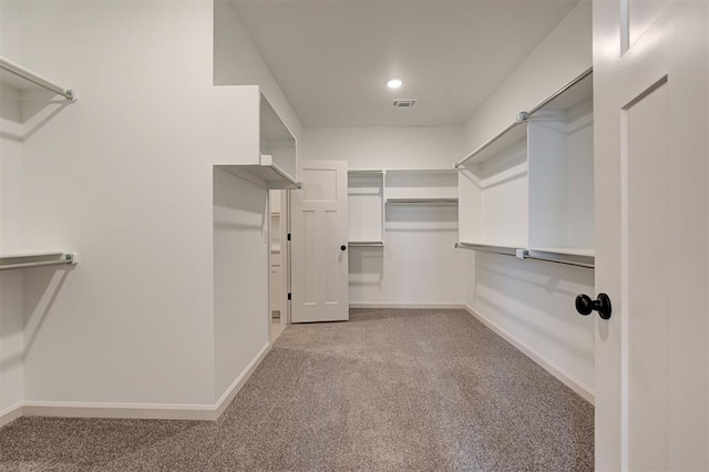 spacious closet featuring visible vents and light carpet