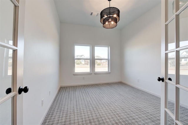 unfurnished room featuring carpet floors, french doors, visible vents, and baseboards