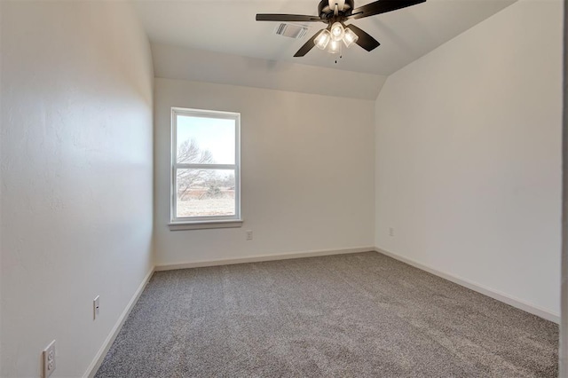 carpeted spare room with visible vents, vaulted ceiling, baseboards, and ceiling fan