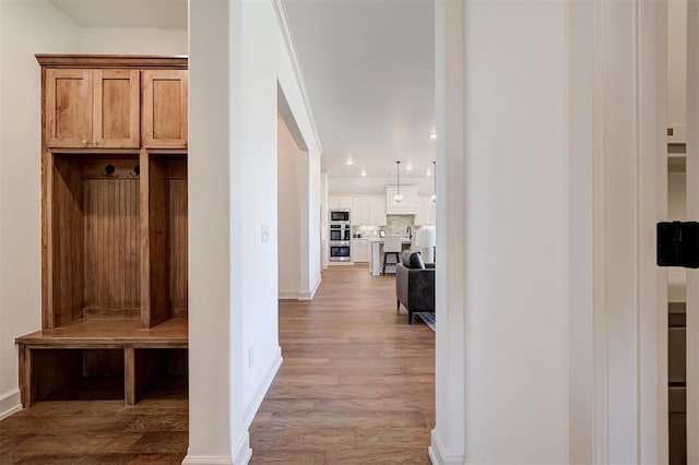 mudroom with recessed lighting, wood finished floors, and baseboards