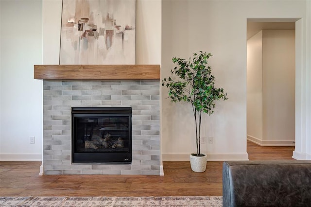 details with a brick fireplace, baseboards, and wood finished floors