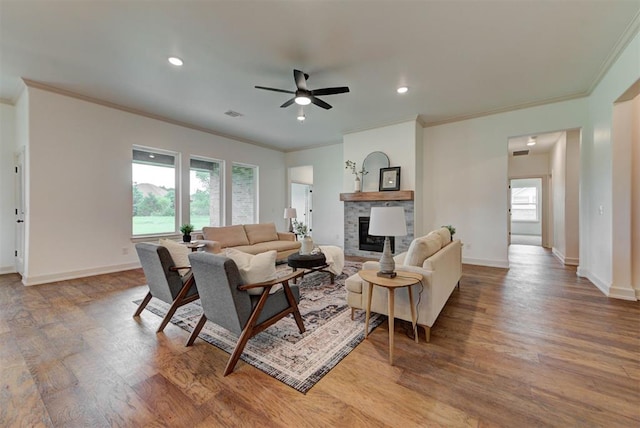 14500 Rushing Ln, Edmond, OK 73025 - living area with wood finished floors, ornamental molding, a ceiling fan, a fireplace, and baseboards