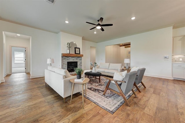 14500 Rushing Ln, Edmond, OK 73025 - living room with crown molding, ceiling fan, a glass covered fireplace, light wood-style flooring, and recessed lighting