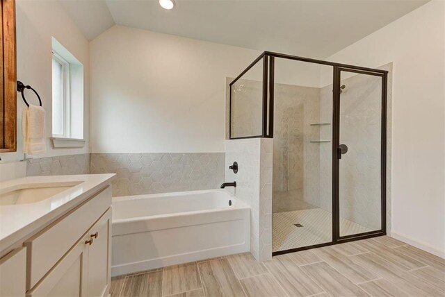 14500 Rushing Ln, Edmond, OK 73025 - full bathroom featuring a stall shower, a garden tub, vanity, wood tiled floors, and vaulted ceiling