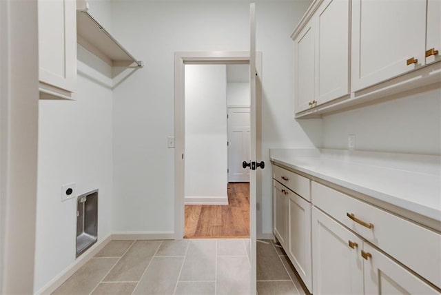 14500 Rushing Ln, Edmond, OK 73025 - washroom with cabinet space, hookup for an electric dryer, light tile patterned floors, and baseboards