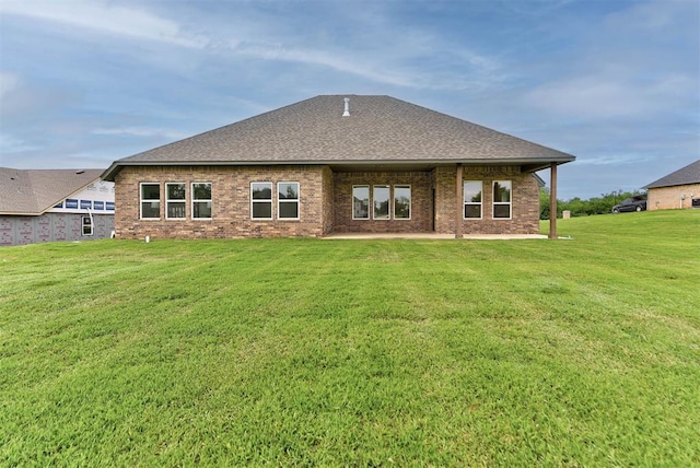 14500 Rushing Ln, Edmond, OK 73025 - rear view of house with a yard, roof with shingles, brick siding, and a patio