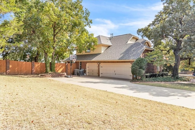 exterior space with cooling unit, a yard, and a garage