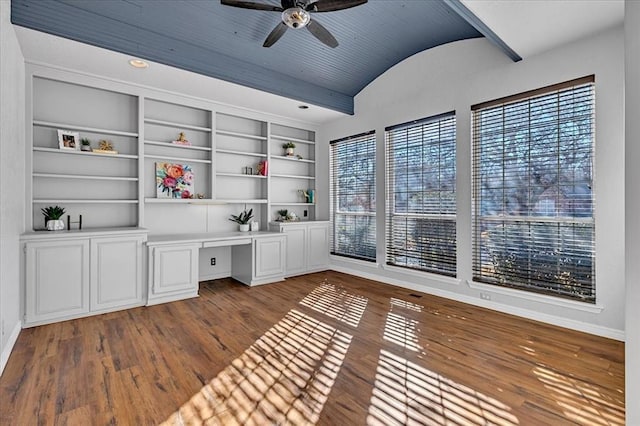 unfurnished office featuring built in desk, built in features, wood-type flooring, lofted ceiling, and ceiling fan