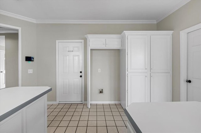 kitchen featuring white cabinetry, crown molding, and light tile patterned floors