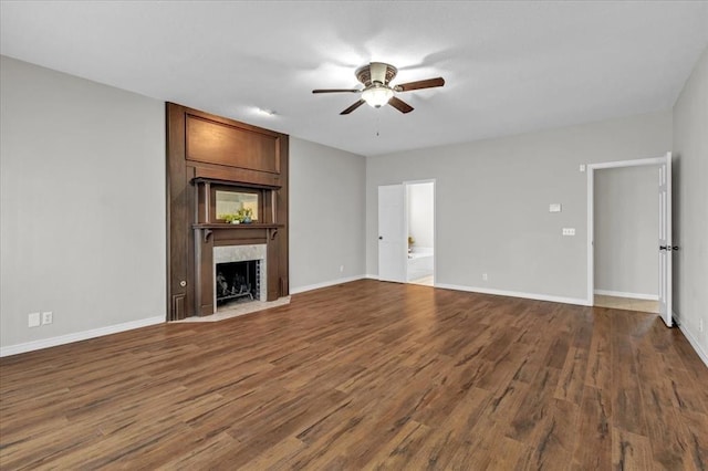 unfurnished living room with hardwood / wood-style flooring, ceiling fan, and a premium fireplace