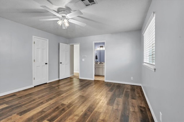 unfurnished bedroom with ceiling fan, connected bathroom, and dark hardwood / wood-style flooring