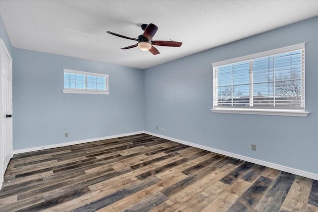 empty room with ceiling fan and dark hardwood / wood-style flooring