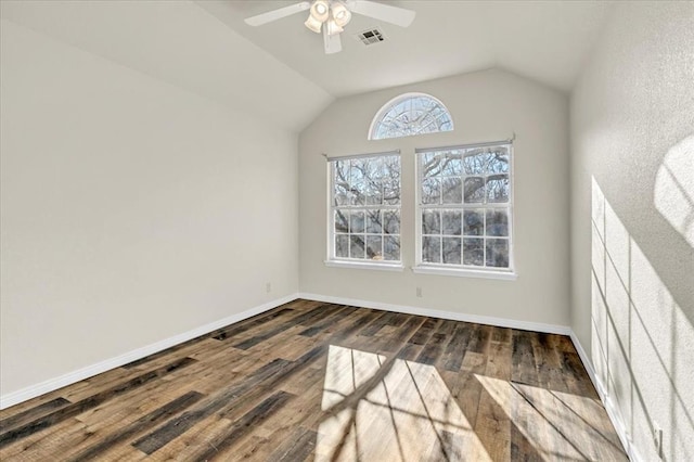 empty room featuring vaulted ceiling, dark hardwood / wood-style floors, and ceiling fan