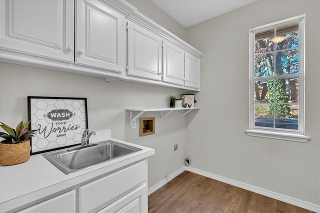 clothes washing area featuring sink, cabinets, hardwood / wood-style flooring, washer hookup, and hookup for an electric dryer