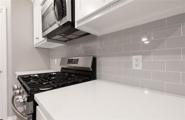 12333 SW 30th St, Yukon, OK 73099 - kitchen featuring appliances with stainless steel finishes, white cabinets, decorative backsplash, and light countertops