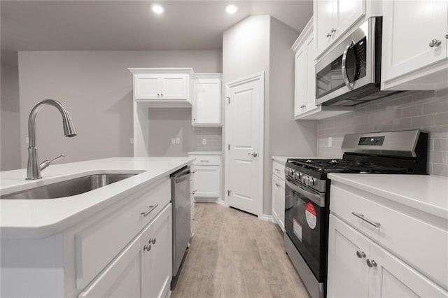 12333 SW 30th St, Yukon, OK 73099 - kitchen with stainless steel appliances, a sink, recessed lighting, white cabinets, and light countertops