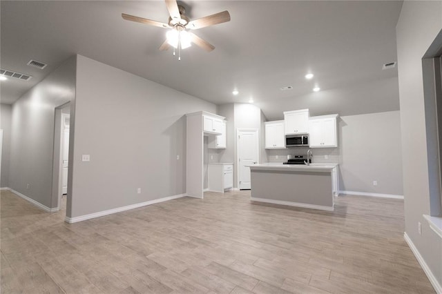 12333 SW 30th St, Yukon, OK 73099 - kitchen featuring appliances with stainless steel finishes, light wood-type flooring, white cabinets, a ceiling fan, and light countertops
