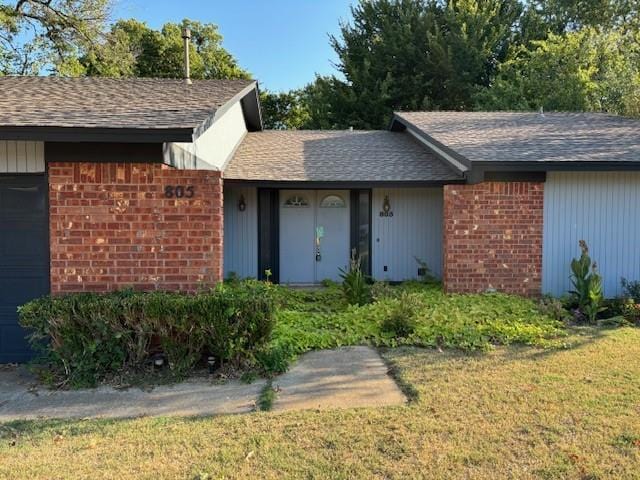 view of exterior entry with a yard and a garage