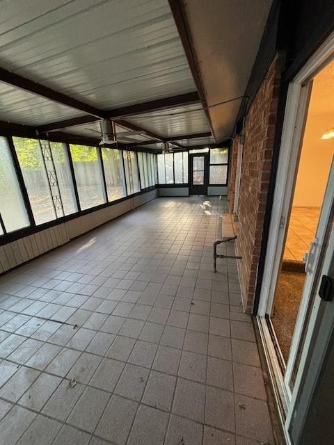 unfurnished sunroom with beamed ceiling