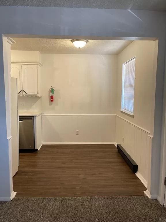 laundry room with a textured ceiling and dark wood-type flooring