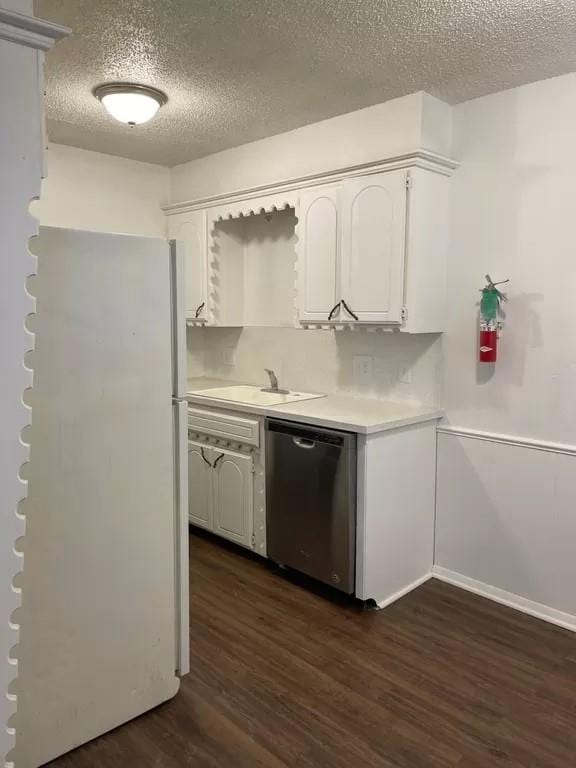 kitchen with dishwasher, sink, dark hardwood / wood-style flooring, a textured ceiling, and white cabinets