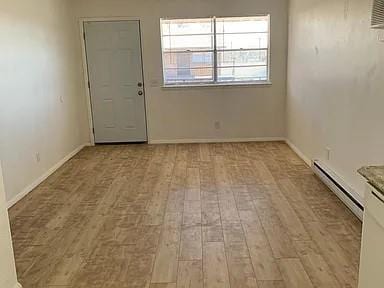 spare room with light hardwood / wood-style floors and a baseboard radiator