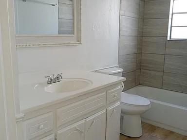 full bathroom with vanity, tiled shower / bath combo, and toilet