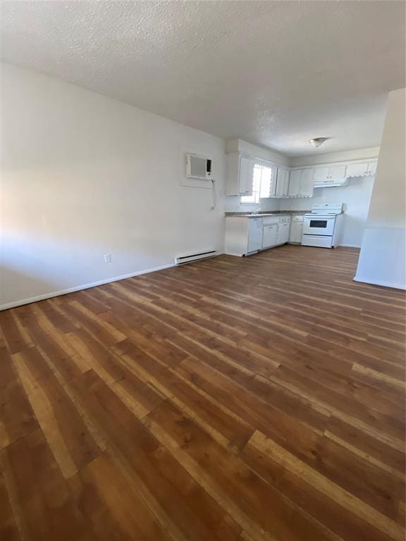 unfurnished living room with a textured ceiling, dark hardwood / wood-style floors, baseboard heating, and a wall mounted AC