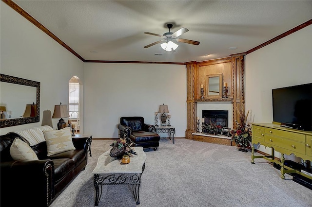 living room featuring carpet, ceiling fan, and ornamental molding