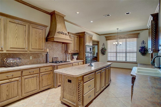 kitchen with sink, ornamental molding, a kitchen island, custom range hood, and stainless steel appliances