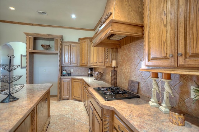 kitchen featuring tasteful backsplash, black gas cooktop, premium range hood, crown molding, and light tile patterned flooring