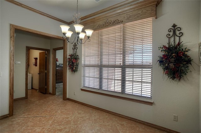 unfurnished dining area with washer / dryer, crown molding, light tile patterned flooring, and an inviting chandelier