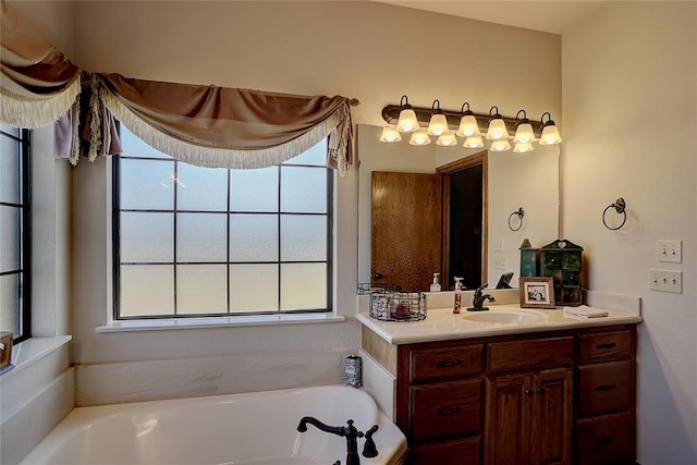 bathroom featuring a tub to relax in, a wealth of natural light, and vanity