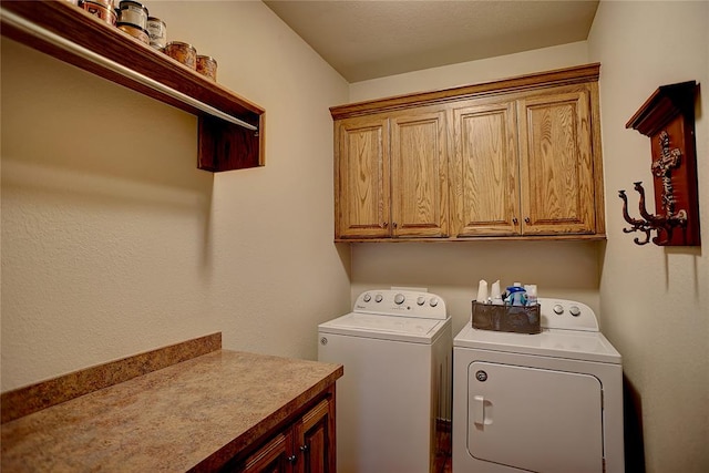 clothes washing area with cabinets and washing machine and clothes dryer