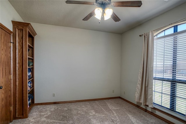 unfurnished room featuring carpet, ceiling fan, and a textured ceiling