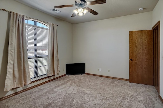 carpeted spare room featuring ceiling fan