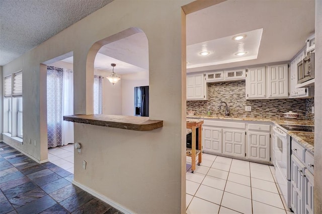 kitchen with sink, tasteful backsplash, kitchen peninsula, white range with electric cooktop, and white cabinets