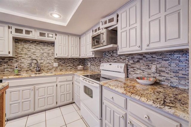 kitchen featuring white electric range oven, white cabinetry, sink, and tasteful backsplash