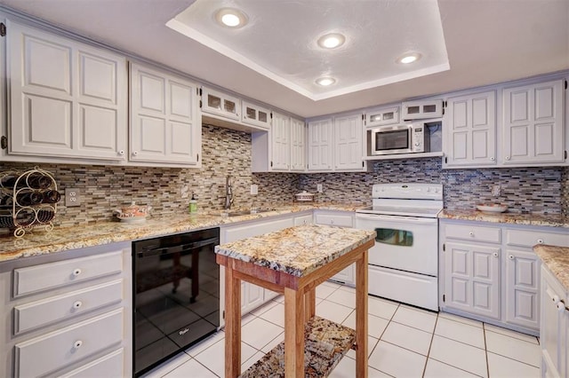 kitchen featuring stainless steel microwave, white electric stove, sink, black dishwasher, and a tray ceiling