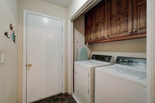 laundry area featuring washer and clothes dryer, cabinets, and a textured ceiling