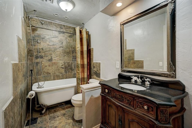 full bathroom featuring vanity, shower / bath combination with curtain, a textured ceiling, and toilet