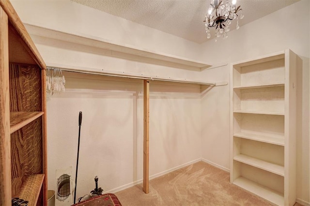 spacious closet featuring carpet floors and an inviting chandelier