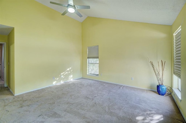 spare room with ceiling fan, light colored carpet, and vaulted ceiling