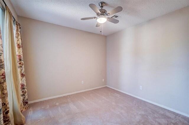 unfurnished room featuring a textured ceiling, ceiling fan, and light carpet