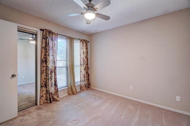 carpeted spare room featuring ceiling fan and a textured ceiling