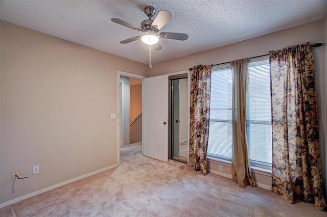 carpeted spare room with ceiling fan and a textured ceiling