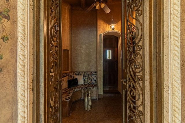 hallway with arched walkways and tile patterned flooring