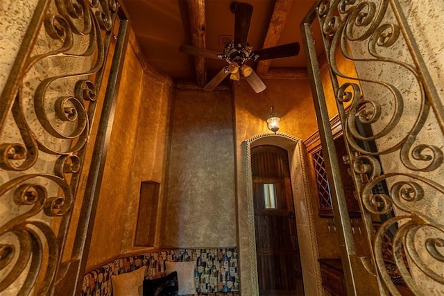 details featuring arched walkways, ceiling fan, and beamed ceiling